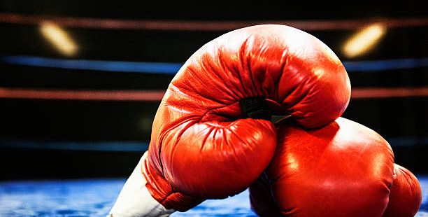 Boxing gloves in boxing ring. Grain added.